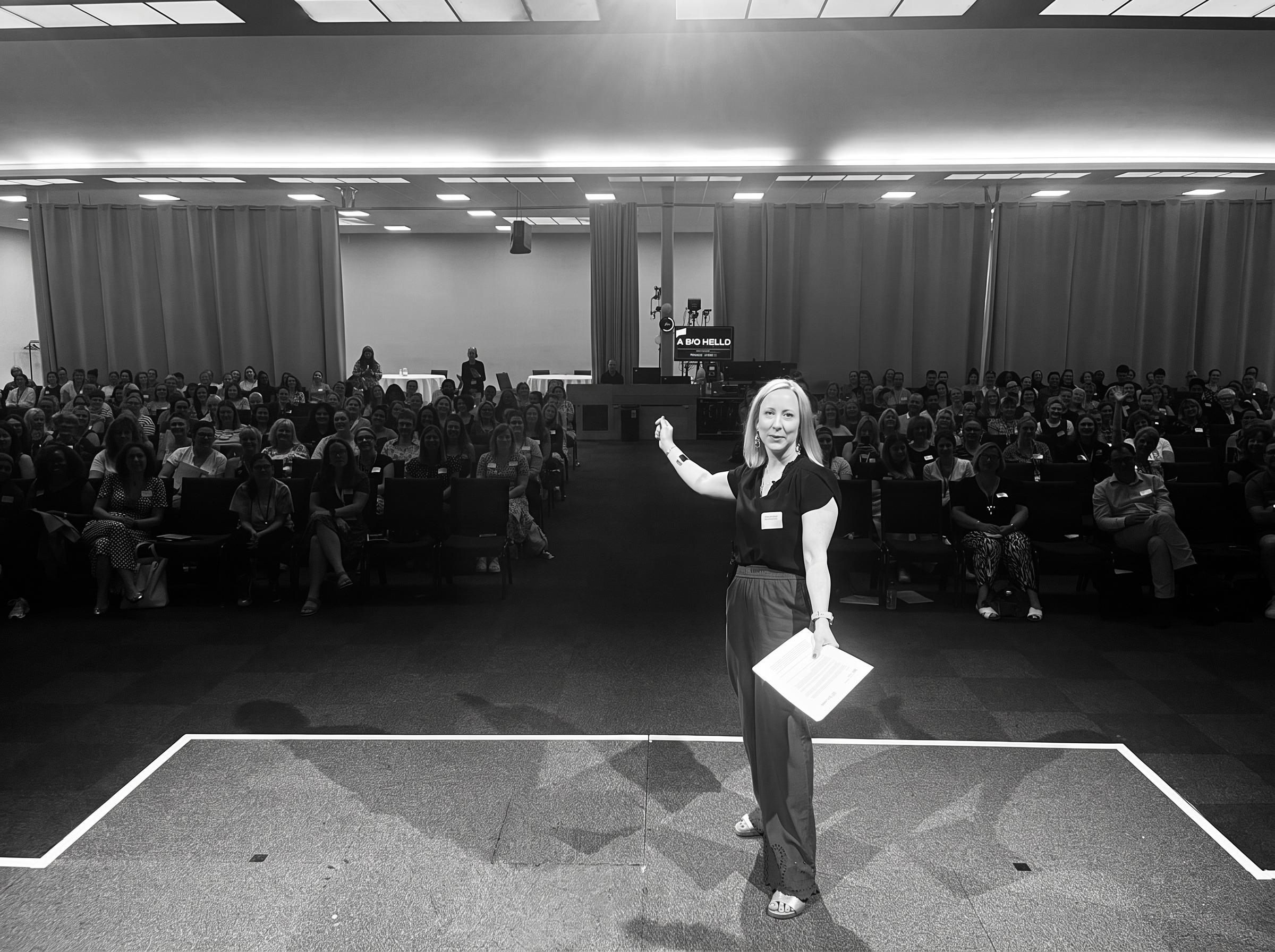 Jodie Lloyd-Jones leading from the stage in front of a full conference audience